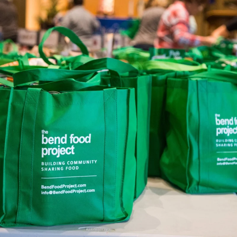 Green Bend Food Project bags filled with donated nonperishable food sit on tables as volunteers prepare for a Neighborhood Food Project Collection Day.