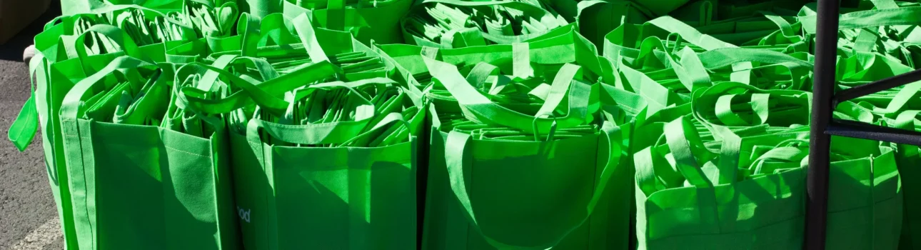 Green food donation bags are gathered together for sorting during a Neighborhood Food Project Collection Day.