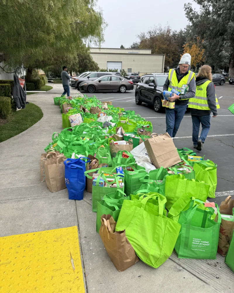Green bags filled with donated nonperishable food are lined up outside as volunteers organize donations during a Collection Day.